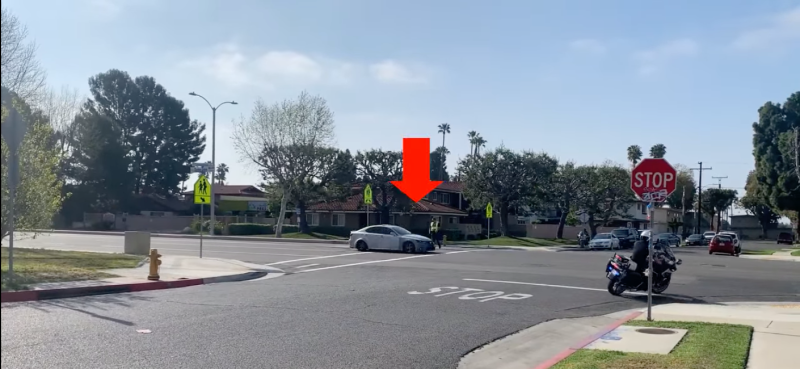 a photo still image from the video that is being described in the blog - shows a car nearly missing a pedestrian in a bright vest walking across a "protected" crosswalk. 