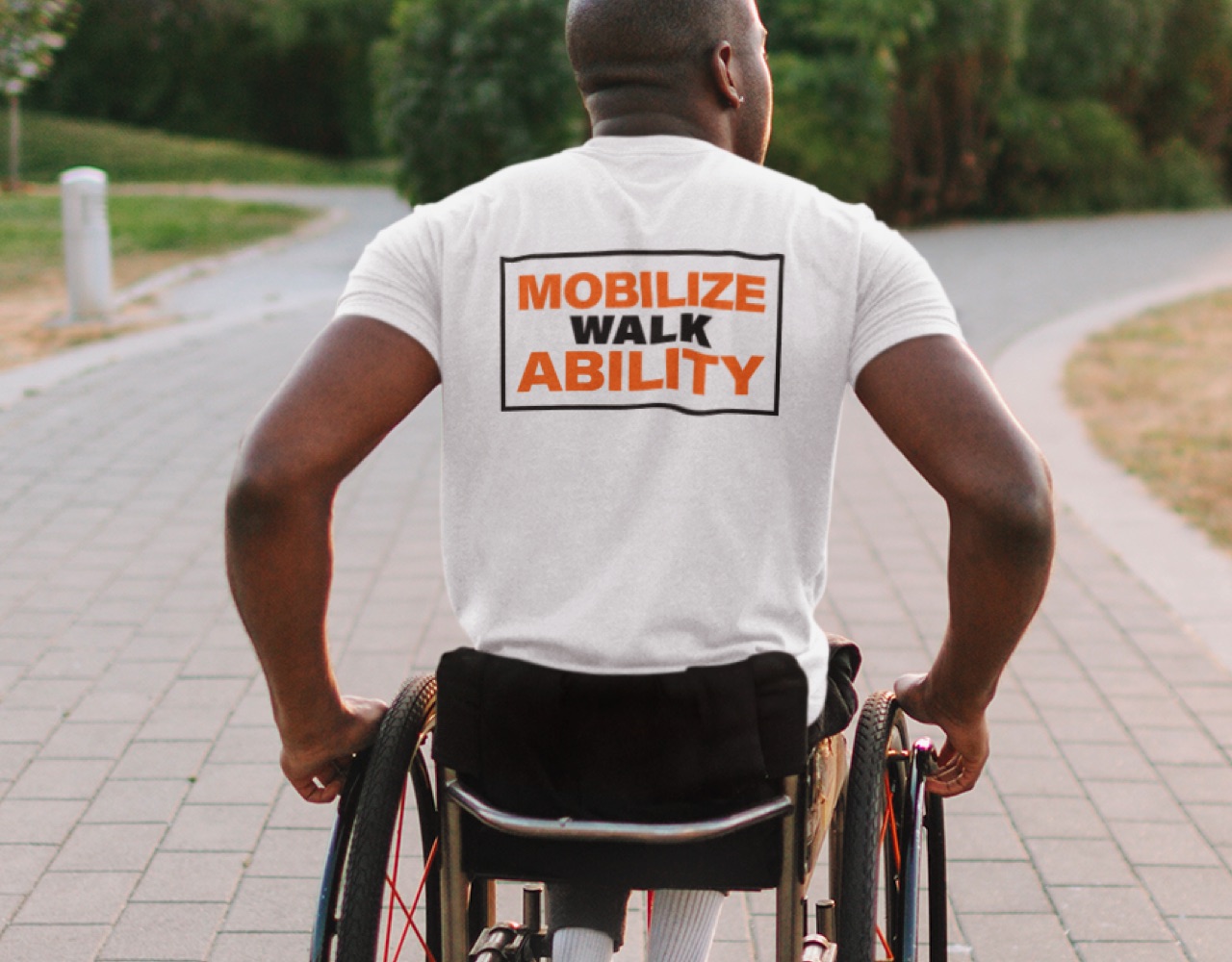 A man in a wheelchair wearing tshirt that says Mobilize Walk Ability