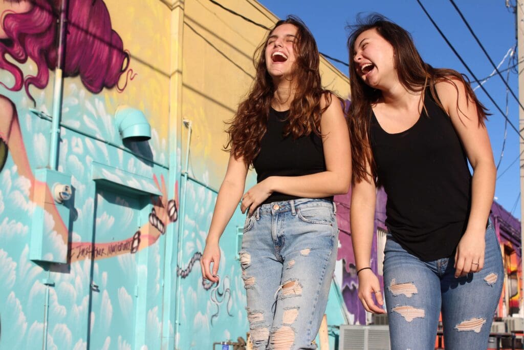 People laughing by community mural art