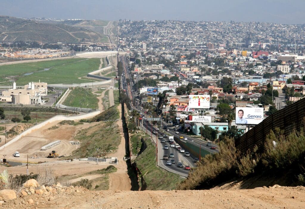 Una pequeña barrera separa a México, densamente poblado, de los Estados Unidos en la frontera.
