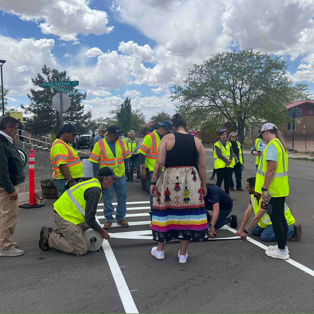 Community members lay down a new crosswalk during a quick-build project in Pueblo Jemez