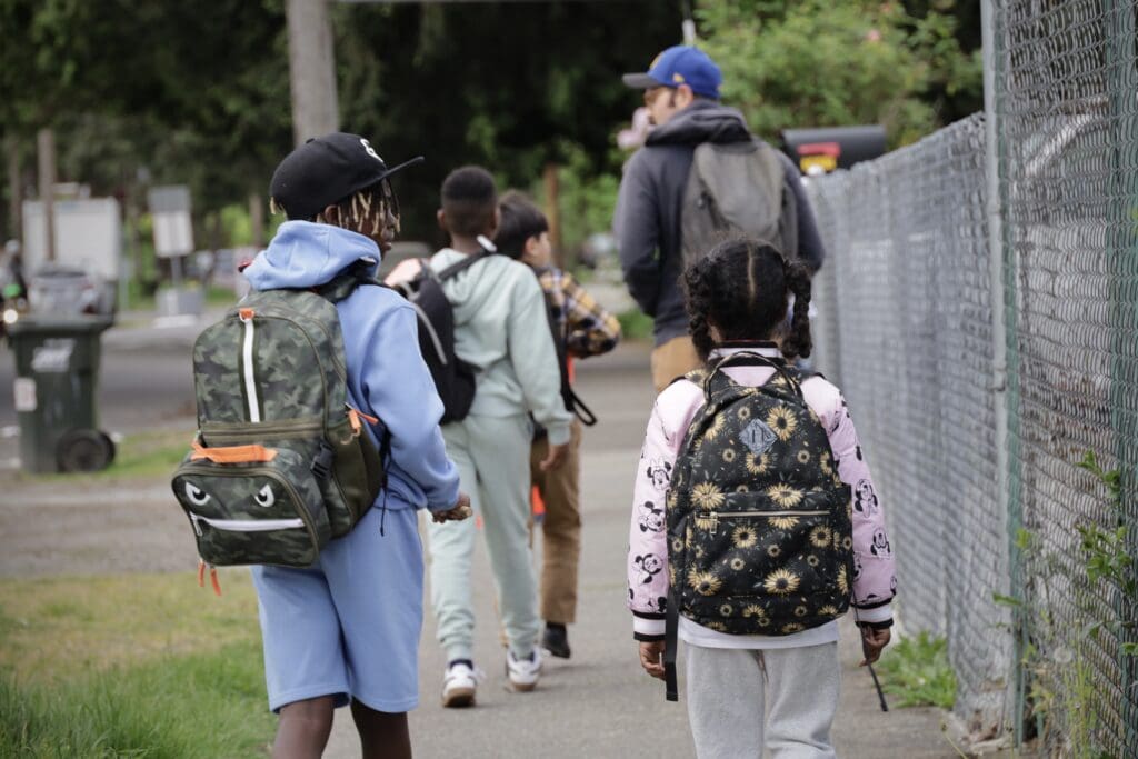 Kids walking to school in a sidewalk