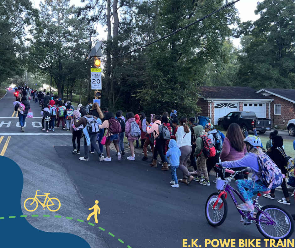 A picture of the E.K. Powe Bike Train showing a group of children and their families biking and walking up a street