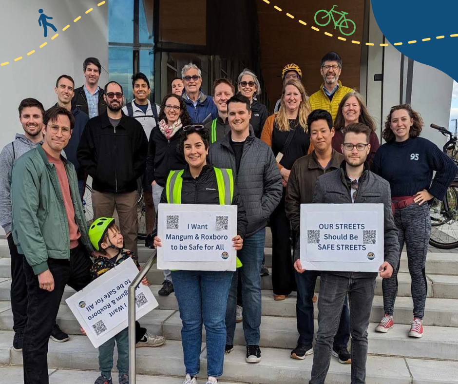 A group of advocates holding signs during that they are supporting safe streets during a council meeting