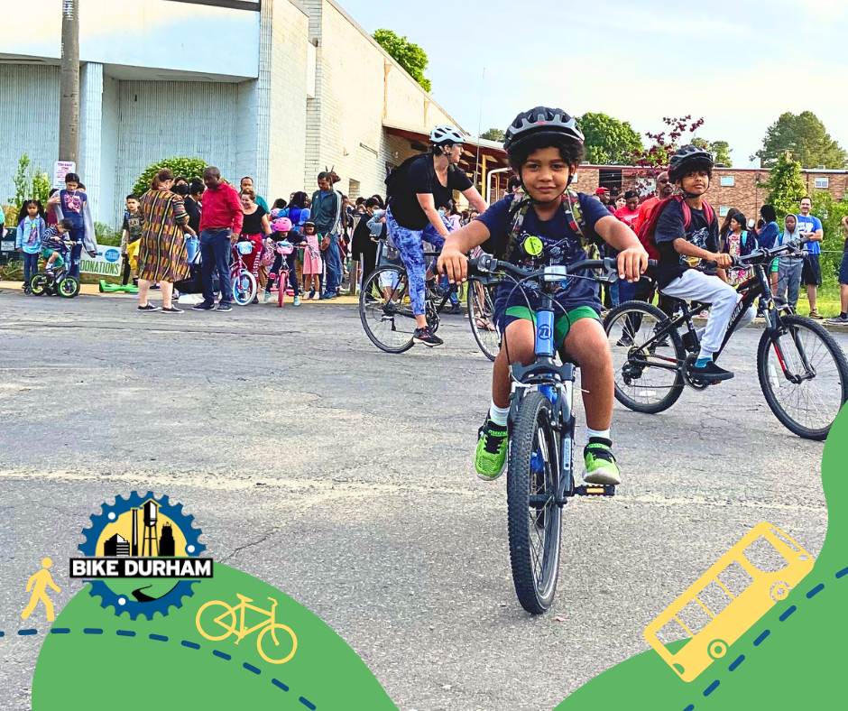 A picture of a young child riding a bike, behind are children and families walking, riding bikes and convening with others