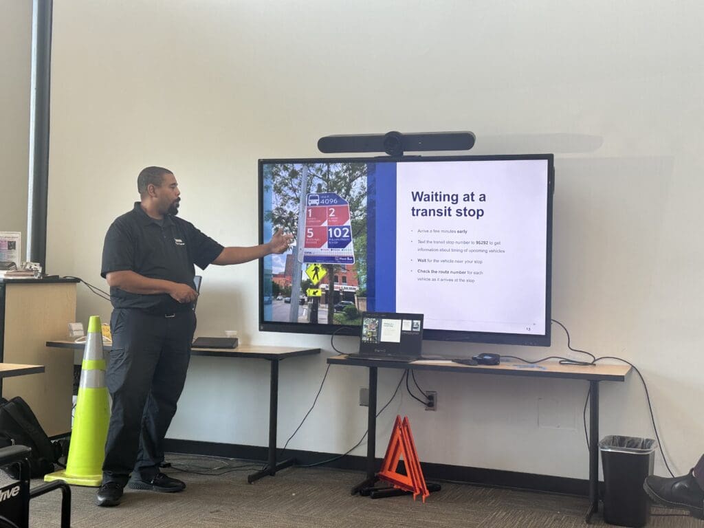 a man presents slides on waiting at a transit stop