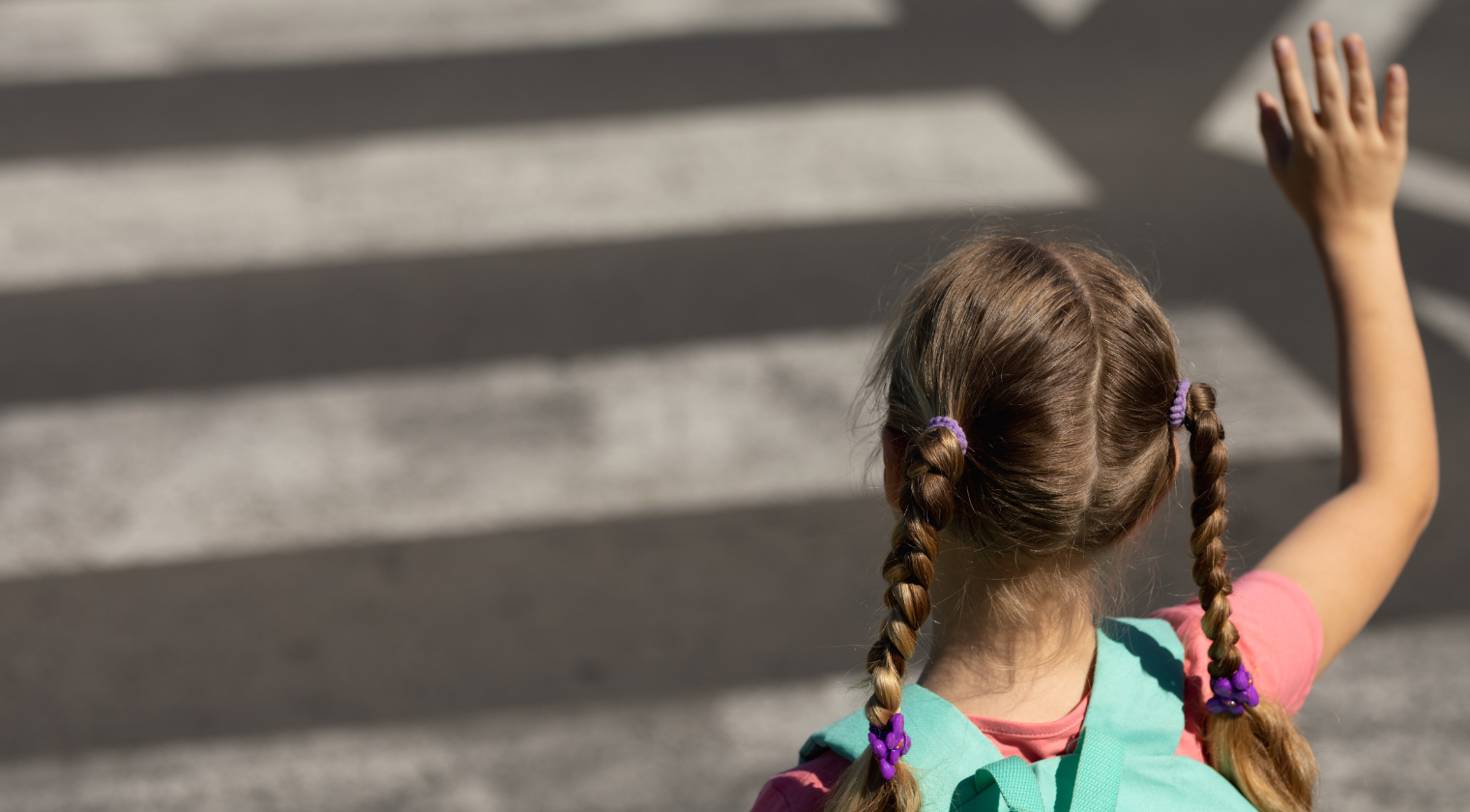girl in a crosswalk waving
