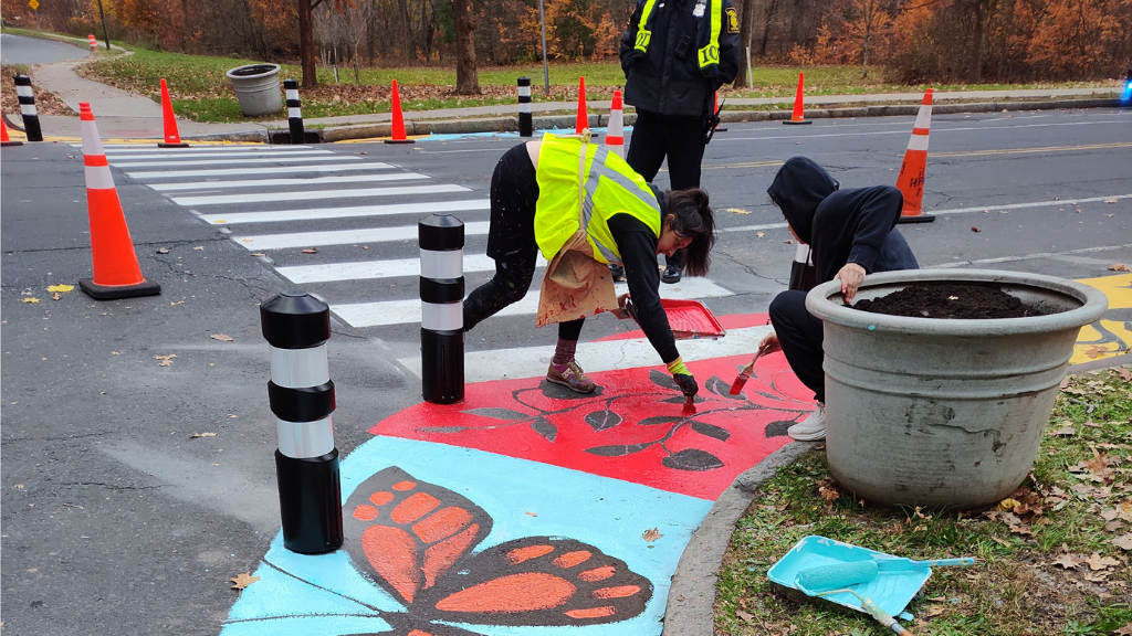 People paint a crosswalk